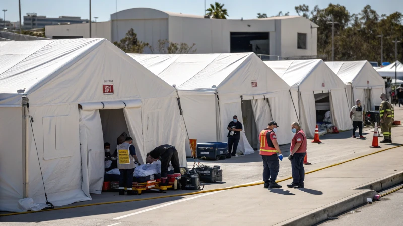 White warehouse tents in an emergency response situation with medical personnel and responders