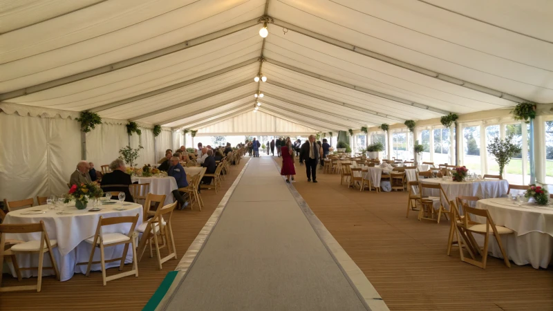 Interior of a spacious event tent with guests mingling