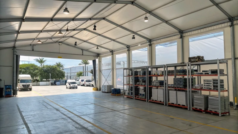 A large industrial tent structure with clear walls in a commercial setting