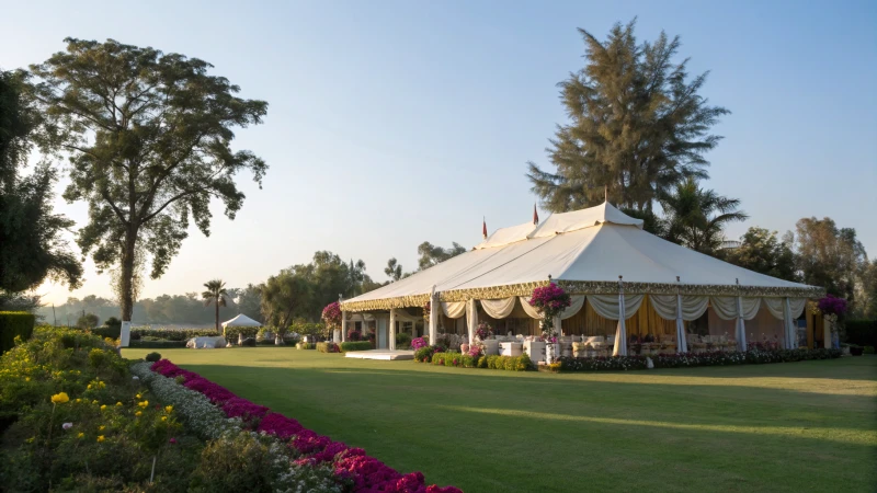 A large decorated marquee tent on green grass surrounded by flowers and trees