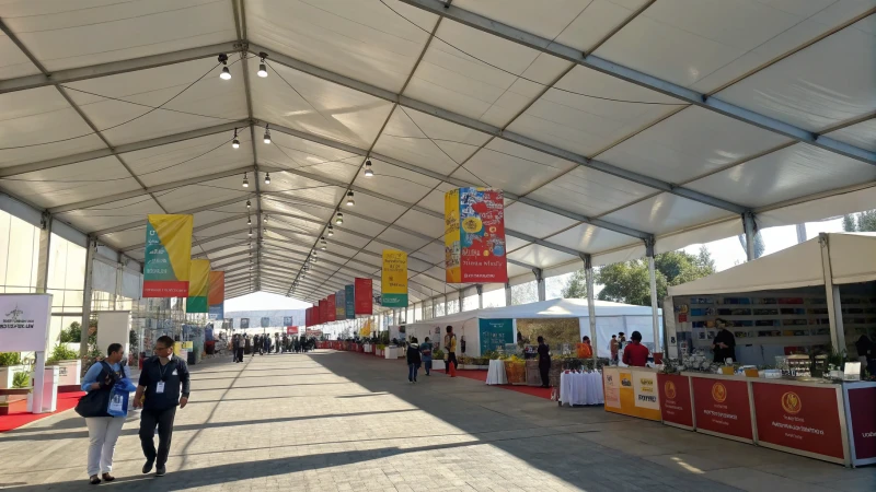 A vibrant outdoor exhibition tent bustling with activity.