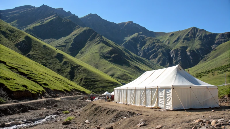 A large white marquee tent on rugged mountainous terrain.